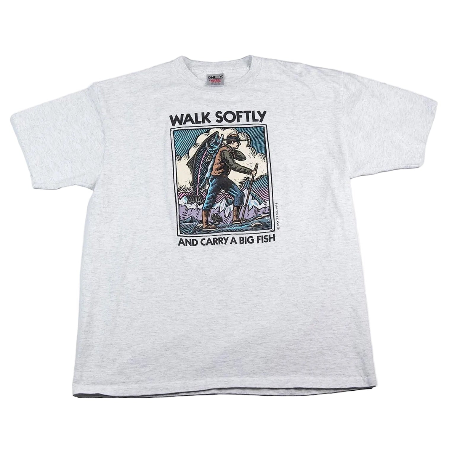 White t-shirt with graphic design and text 'Walk Softly and Carry a Big Fish' on a white background