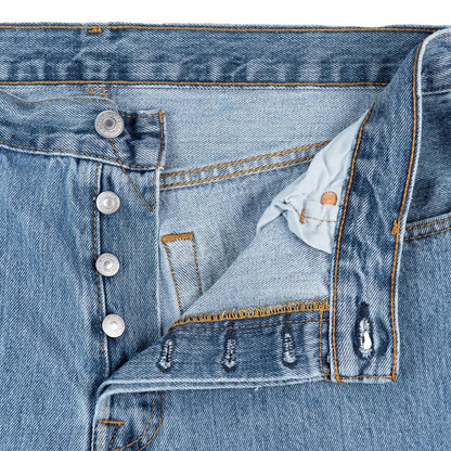 Close-up of a blue denim jacket with buttons and a collar.