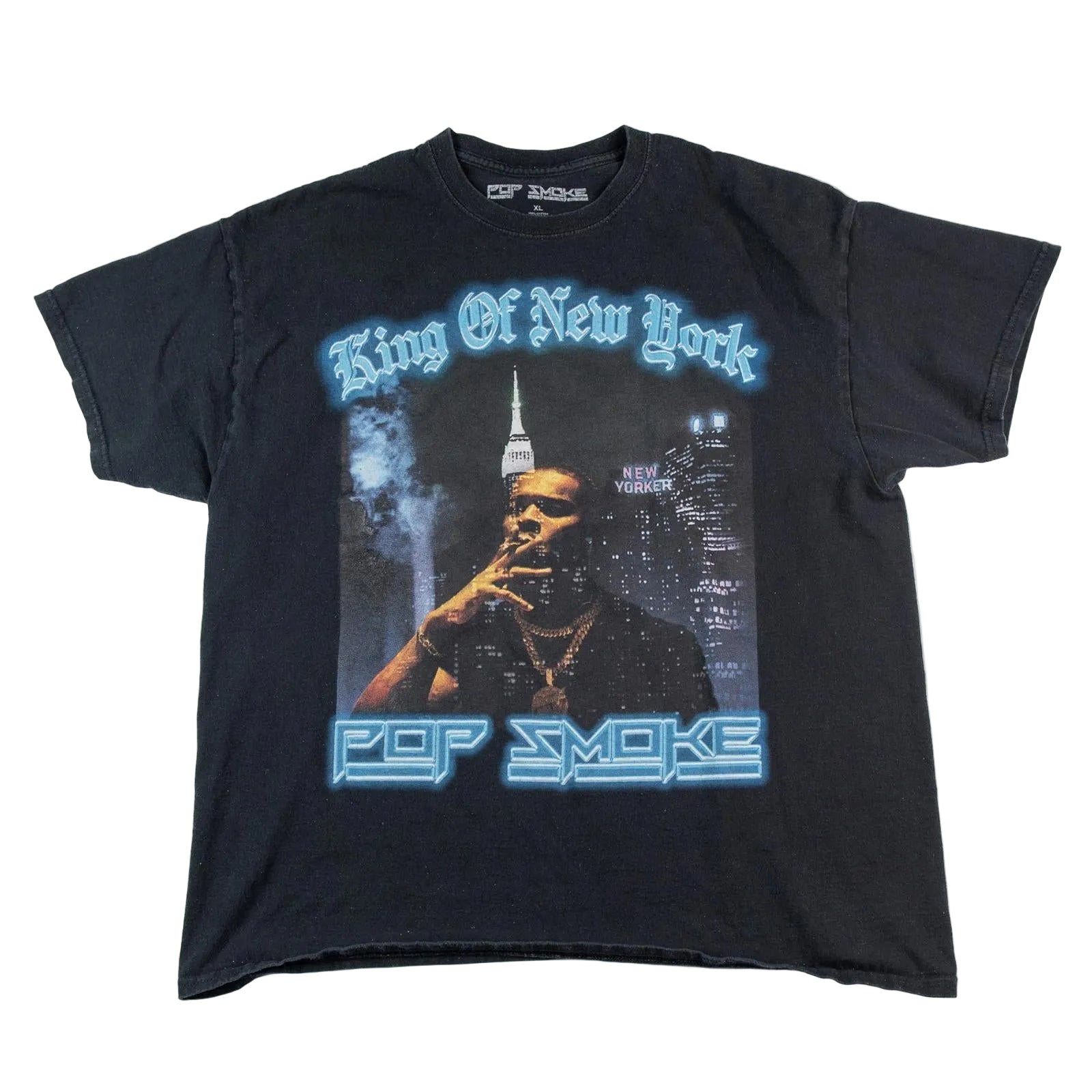 Black t-shirt with graphic design of a person smoking and text 'King Of New York' and 'Pop Smoke' on a white background.