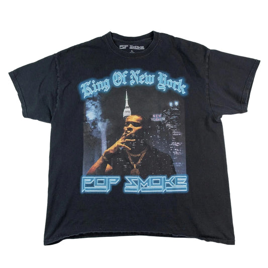 Black t-shirt with graphic design of a person smoking and text 'King Of New York' and 'Pop Smoke' on a white background.